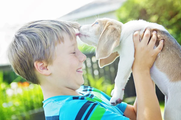 Barn omfamnar kärleksfullt sin hund — Stockfoto