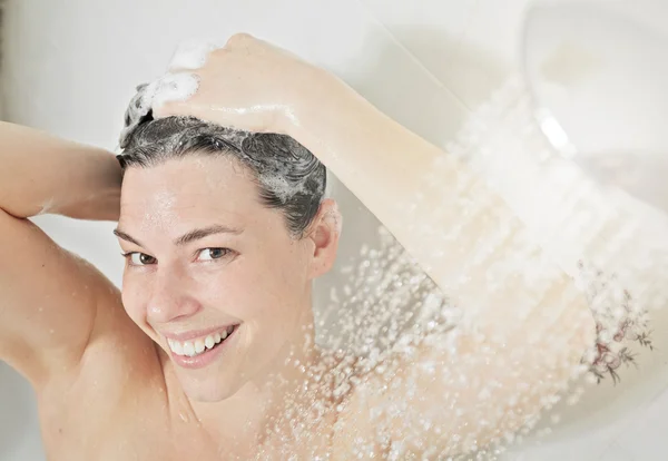 Mulher do chuveiro. Feliz sorrindo mulher lavando ombro tomando banho em — Fotografia de Stock