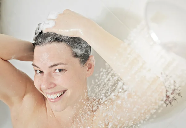 Ducha mujer. Feliz mujer sonriente lavándose el hombro duchándose en —  Fotos de Stock