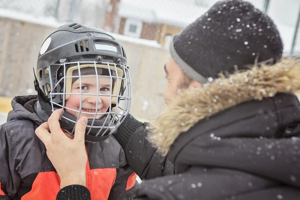 A family playing at the skating rink in winter. — Stock Photo, Image