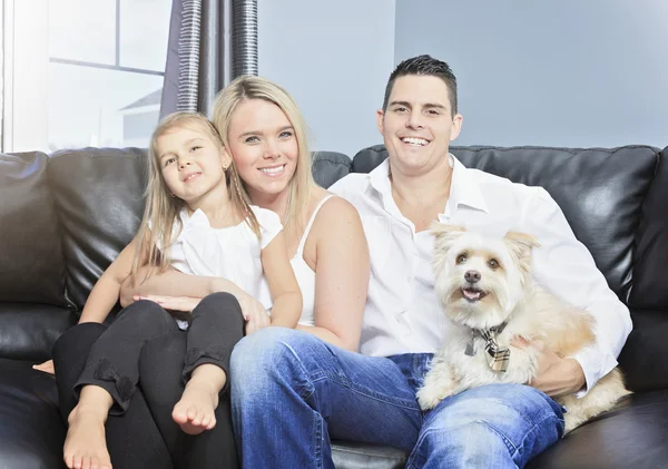 Family with pets sit on sofa at home — Stock Photo, Image