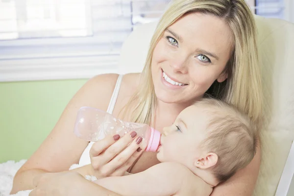 Молодая мать дома кормит свою новую малышку молочным ботом — стоковое фото
