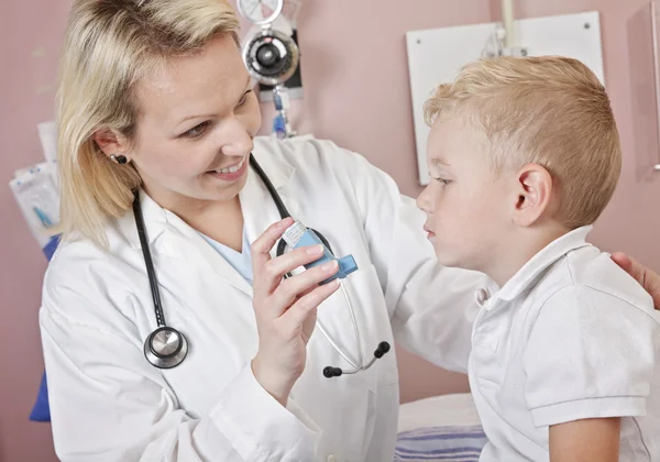 Médico que aplica tratamiento de oxígeno en un niño pequeño con como — Foto de Stock