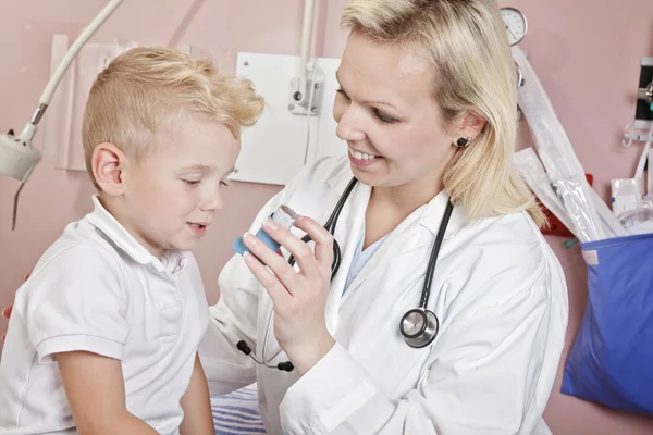 Médico que aplica tratamiento de oxígeno en un niño pequeño con como — Foto de Stock