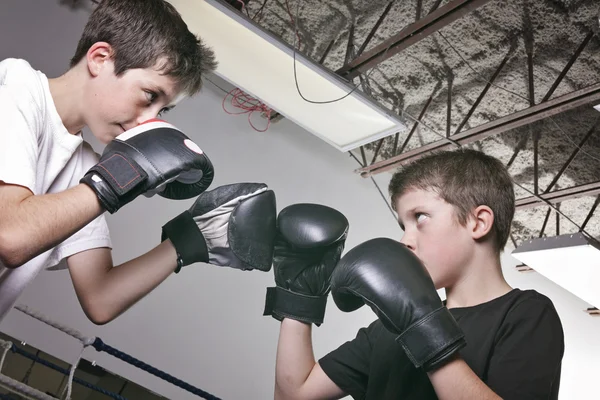 Menino com luvas de boxe preto luta com é irmão — Fotografia de Stock