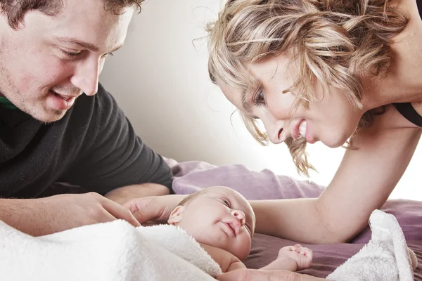 Um belo casal com bebê na cama . — Fotografia de Stock