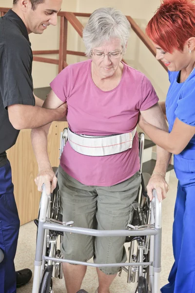 Idosa com seus fisioterapeutas em um hospital — Fotografia de Stock