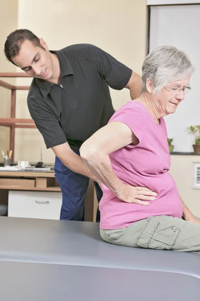 Oudere dame met haar fysiotherapeut in een ziekenhuis — Stockfoto