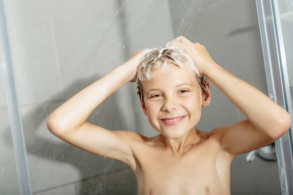 Gelukkig tiener jongen wassen hoofd in de douche in de badkamer — Stockfoto