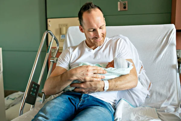 Father with her newborn baby at the hospital a day after birth