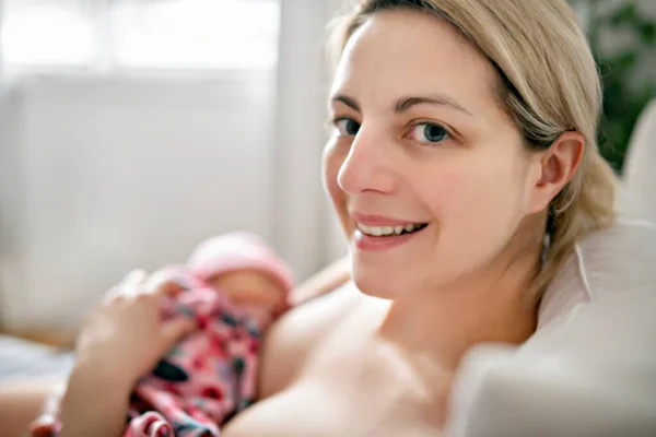 Donna nella sua camera da letto allattare il suo bambino. — Foto Stock