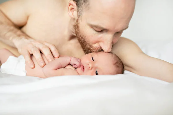 Un padre con un neonato a letto — Foto Stock