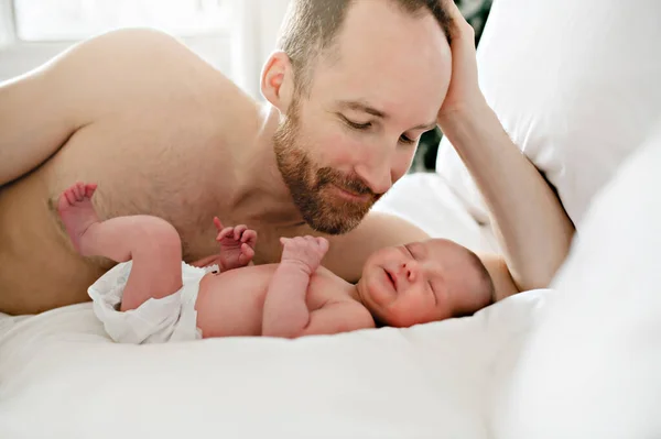 Un padre con un neonato a letto — Foto Stock