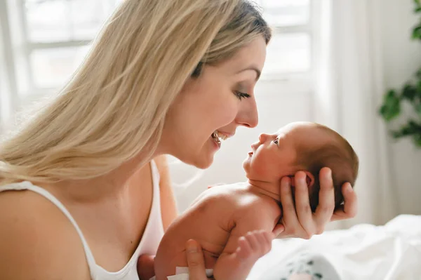 Uma mulher com um bebê recém-nascido na cama — Fotografia de Stock