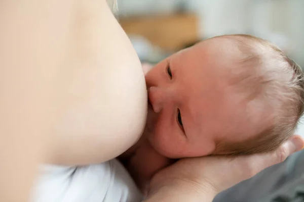 Мать в своей спальне кормит грудью своего ребенка. — стоковое фото
