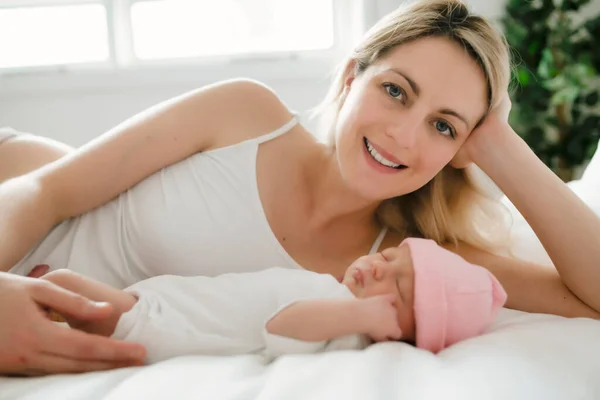 A woman with a newborn baby in bed — Stock Photo, Image