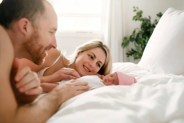 Un padre de familia con un bebé recién nacido en la cama — Foto de Stock