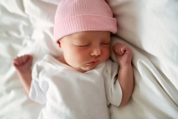 Una dulce niña recién nacida durmiendo en una cama blanca —  Fotos de Stock