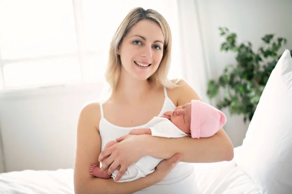 A woman with a newborn baby in bed — Stock Photo, Image