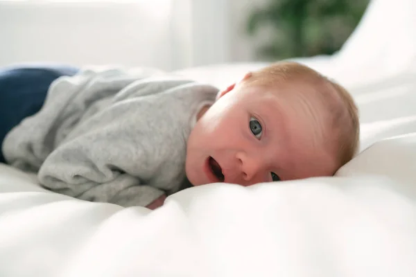 Χαριτωμένο νεογέννητο κοριτσάκι στο λευκό κρεβάτι — Φωτογραφία Αρχείου