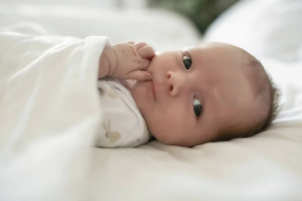 Una dulce niña recién nacida durmiendo en una cama blanca —  Fotos de Stock