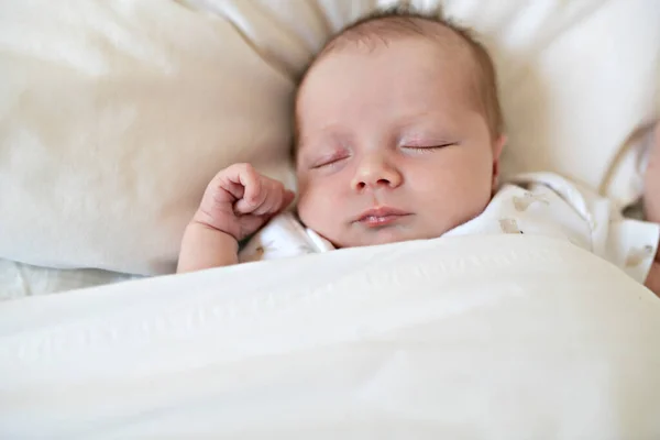 Una dulce niña recién nacida durmiendo en una cama blanca —  Fotos de Stock