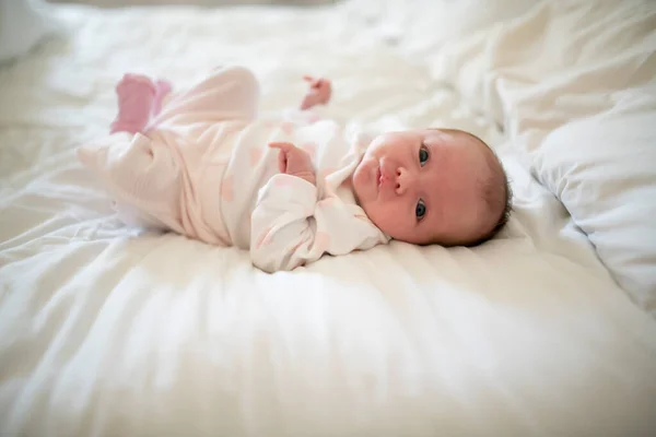 Cute newborn baby girl on the white bed — Stock Photo, Image