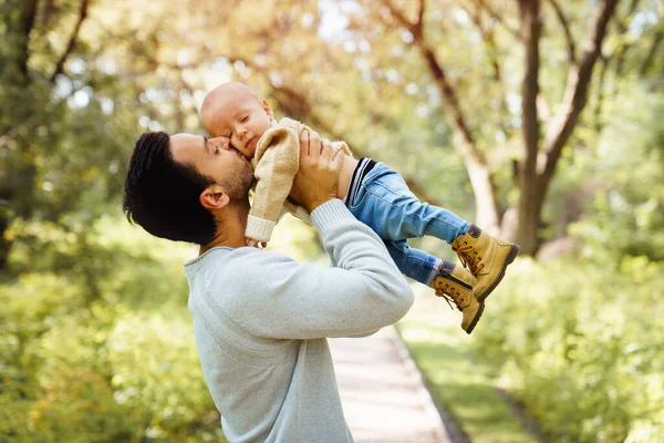 Father and baby having fun in the forest holding his baby in the air — Stock Photo, Image