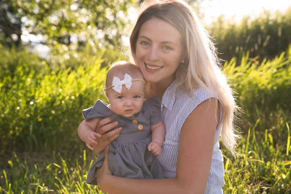Happy mother with little daughter spending time together in sunny field — Stock Photo, Image