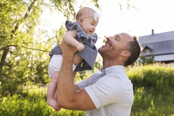 Joyeux papa avec sa petite fille passant du temps ensemble dans un champ ensoleillé — Photo