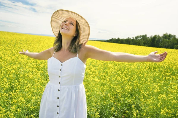 Bella giovane donna felice sul campo di colza in fiore — Foto Stock
