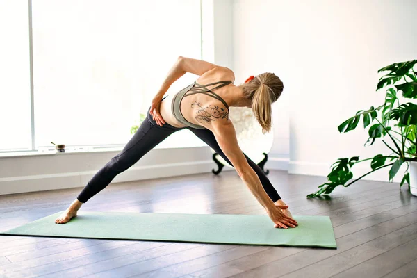 Nice yoga teacher woman in a studio indoors — Stock Photo, Image