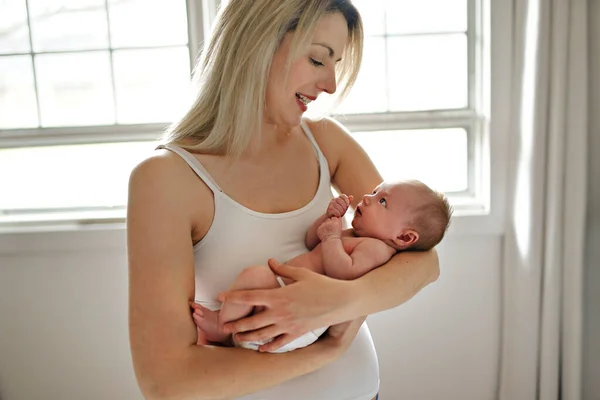 A Beautiful mother holding her cute baby daughter — Stock Photo, Image