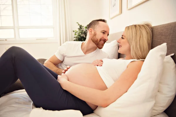 Mulher grávida bonita e seu marido bonito passar o tempo juntos na cama — Fotografia de Stock