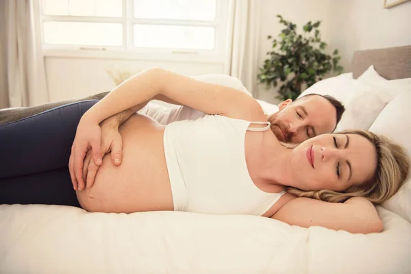 Belle femme enceinte et son beau mari passent du temps ensemble au lit — Photo