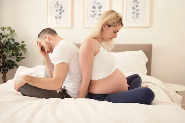 Femme enceinte et son petit ami sur le lit à la maison ayant mal à la tête — Photo