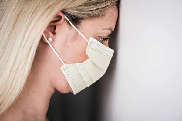 Hoofd en schouders portret van vrouwelijke arts dragen beschermende masker tegen witte achtergrond — Stockfoto