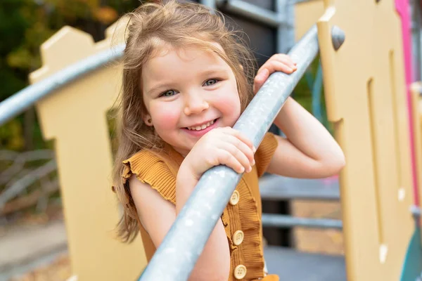 Happy Uśmiechnięte dziecko dziewczyna bawiące się na placu zabaw na świeżym powietrzu w ładnym parku — Zdjęcie stockowe
