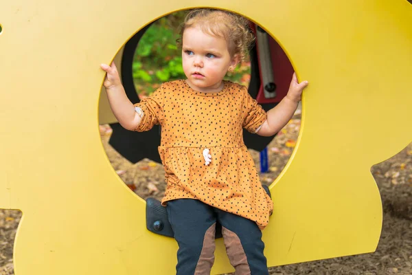 Glad leende barn flicka leka på lekplatsen utomhus i en trevlig park — Stockfoto