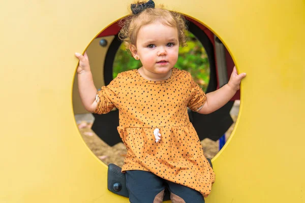 Sorrindo feliz menina brincando no playground ao ar livre em um parque agradável — Fotografia de Stock