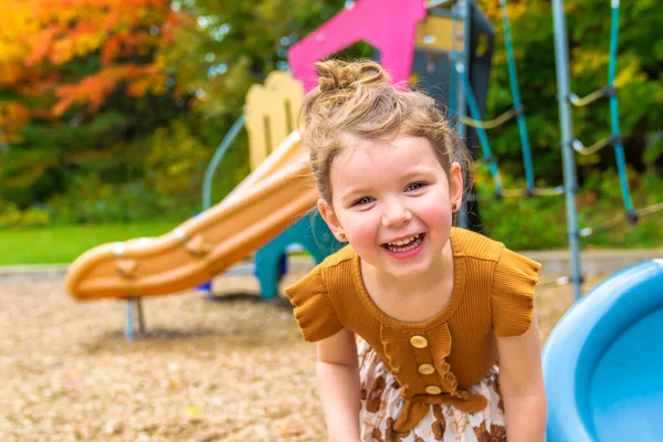 Šťastné usmívající se dítě dívka hrát na hřišti venku v pěkném parku — Stock fotografie