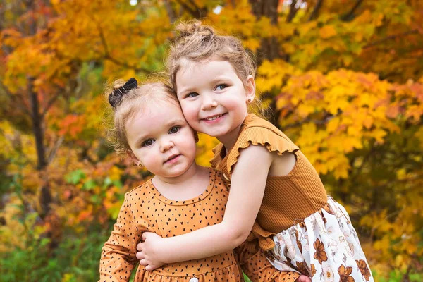 Zwei kleine Schwestern an einem Herbsttag dicht beieinander — Stockfoto