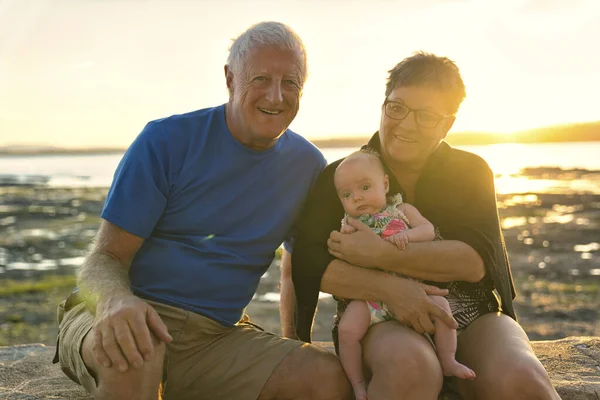 Los abuelos jugando con su nieta bebé en la playa — Foto de Stock