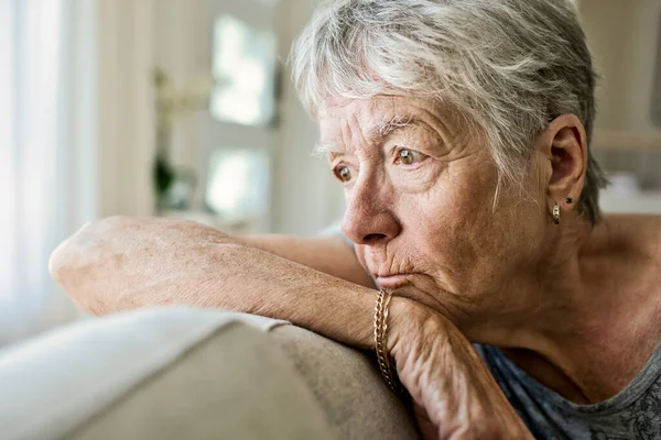 Porträtt av pensiv äldre kvinna på soffan lider av depression — Stockfoto