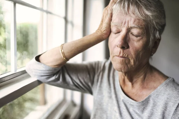 Una mujer mayor preocupada en casa cayendo muy mal —  Fotos de Stock