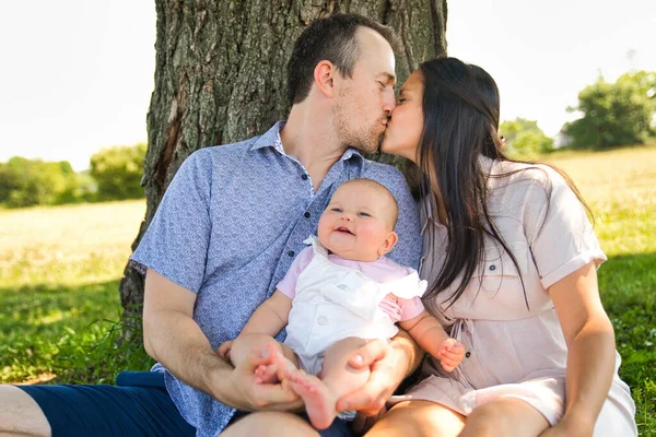 Happy and young family relaxing together in nature — Stock Photo, Image