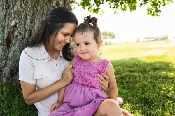 Eine Mutter mit Tochter steht draußen am Baum — Stockfoto