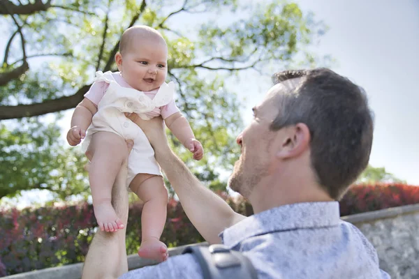 Père avec bébé fille debout à l'extérieur par arbre. — Photo