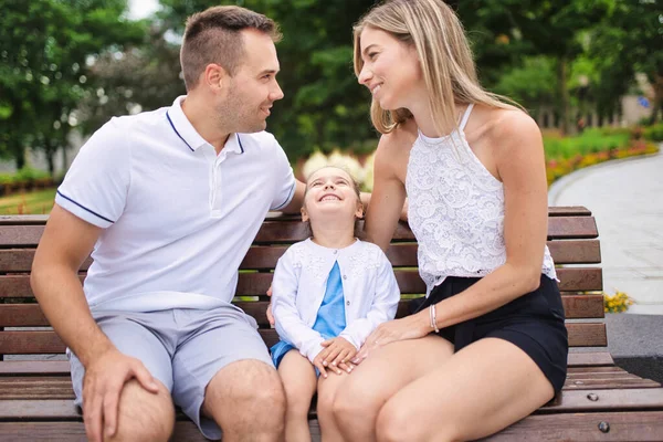 Gelukkig jong gezin zitten op bank buiten in de zomer dag — Stockfoto
