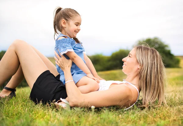 Lycklig mor med sin dotter låg på marken — Stockfoto